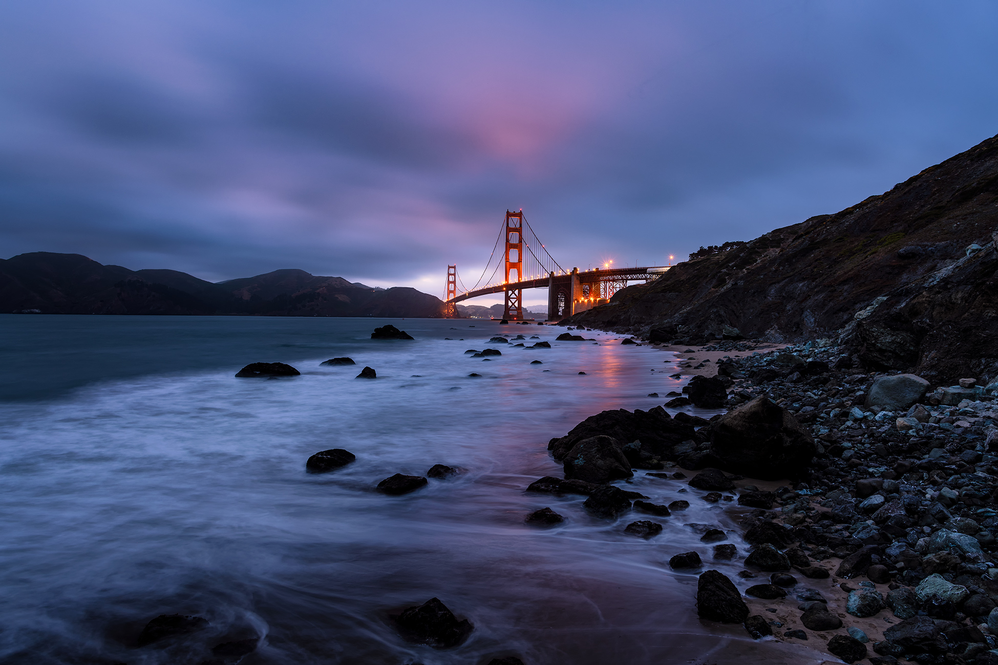 Golden Gate Bridge and beach waves at night