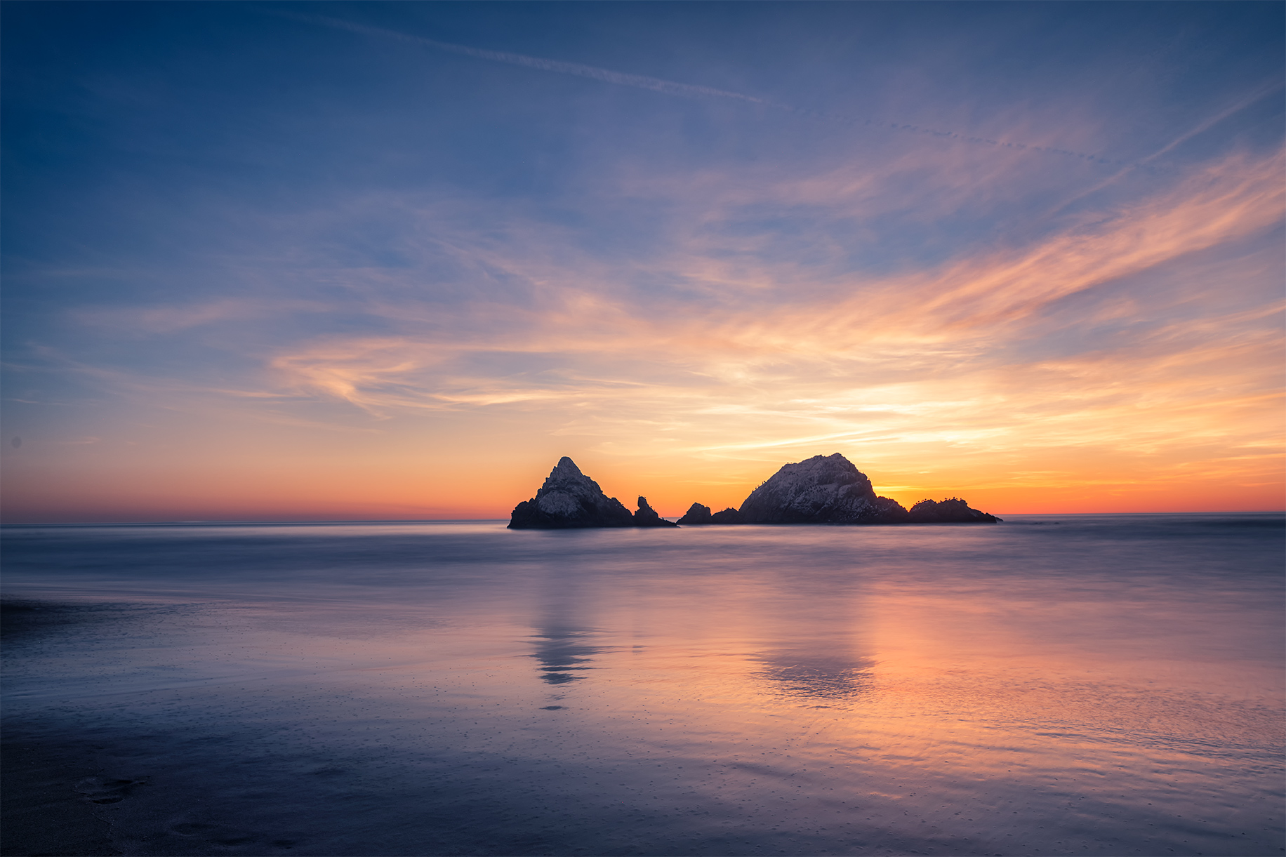 Sunset over the beach and two coastal rocks in San Francisco